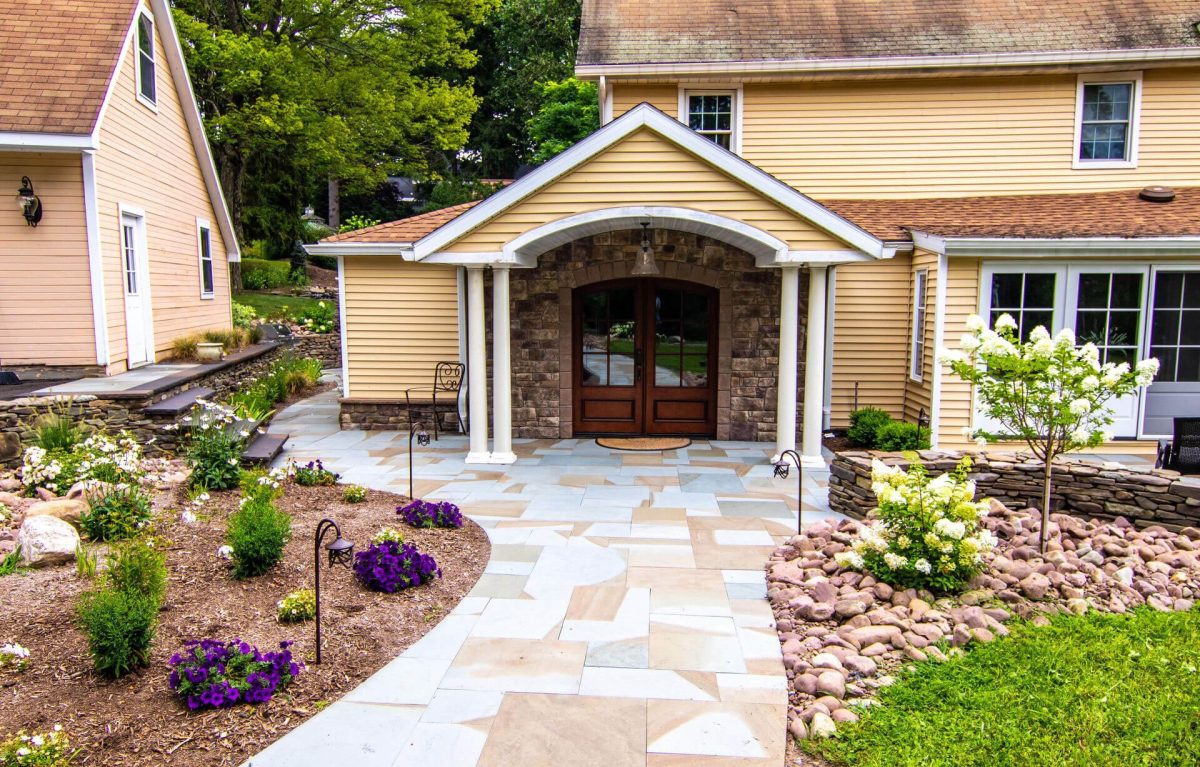 a house with a natural stone driveway and a walkway leading to the front door