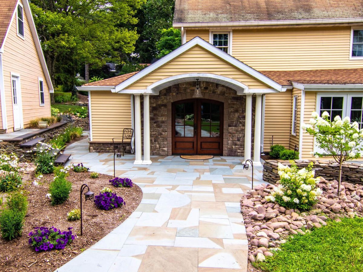 a house with a natural stone driveway and a walkway leading to the front door