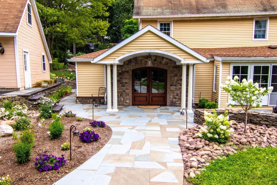 a house with a natural stone driveway and a walkway leading to the front door