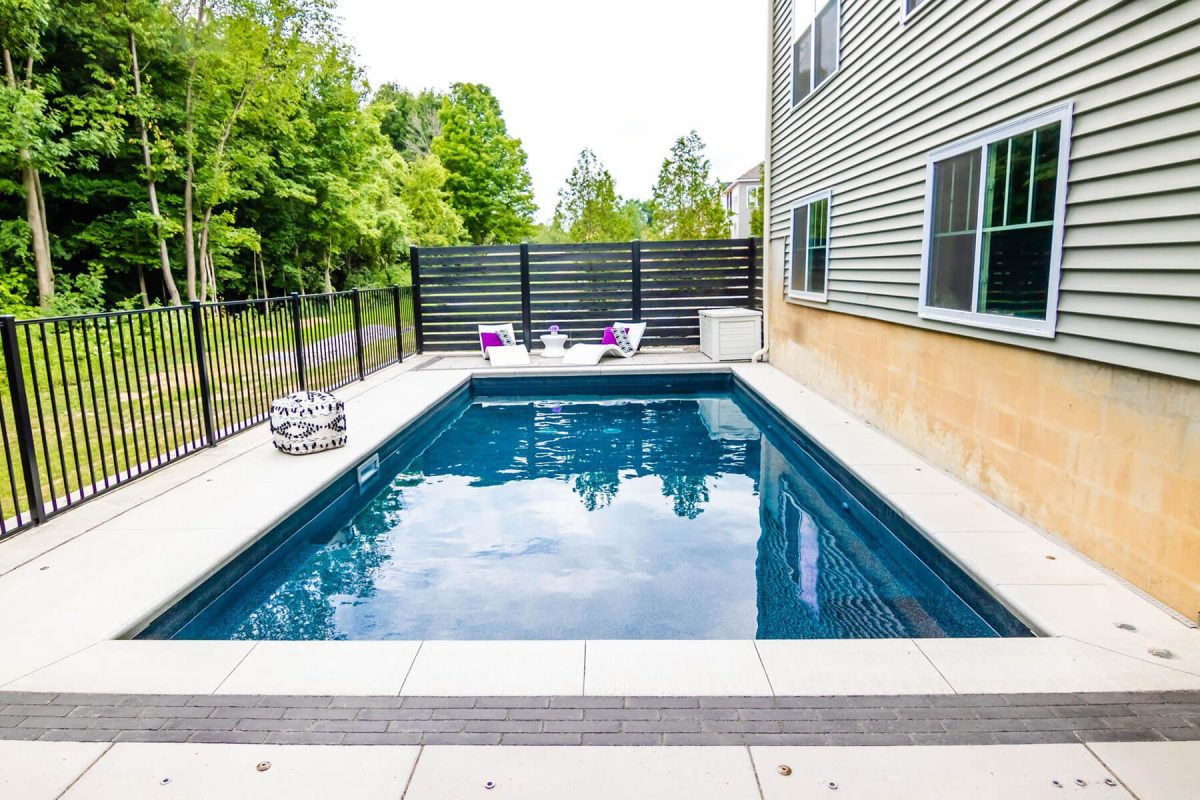 large inground swimming pool in the backyard of a house